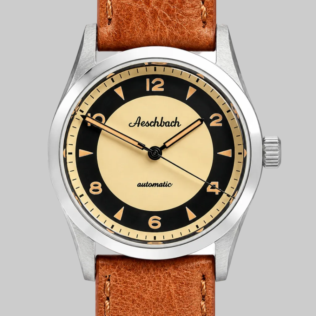 Watch with brown leather strap and black dial on a white background