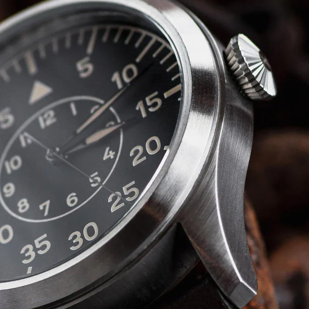 Close-up of a watch with a black face and silver case.